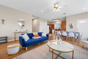 uma sala de estar com um sofá azul e uma mesa em Taste of Everything House 5 from Baylor & Magnolia em Waco