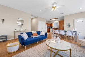 a living room with a blue couch and a table at Taste of Everything House 5 from Baylor & Magnolia in Waco