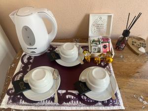 a table with a tea kettle and plates on it at Corso 41 in Bosa