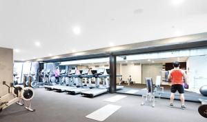 a person standing in a gym with weights at Readyset Apartments at Manhattan in Melbourne