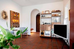 a living room with a flat screen tv on a tile floor at Months and Seasons Design-led Country House in Daylesford
