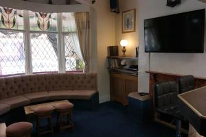 a living room with a couch and a television at OLIVERS Strickley over 35 years only in Blackpool