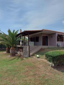a house with a palm tree in front of it at Andre House in Mesimvría