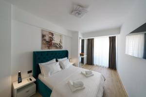 a bedroom with a bed with two towels on it at Afrodita Infinity Beach Pool&Spa Mamaia Nord in Mamaia Nord