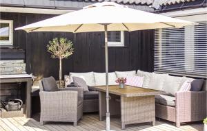 a patio with a table and chairs and an umbrella at Nice Home In Skien With Outdoor Swimming Pool, Heated Swimming Pool And Private Swimming Pool in Skien