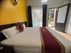 sypialnia z dużym łóżkiem i oknem w obiekcie Tam Coc Tea House Homestay w mieście Ninh Binh