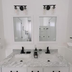 a white bathroom with two sinks and two mirrors at Walk to French Quarter House of Jazz & Blue Suite in New Orleans +34 photos