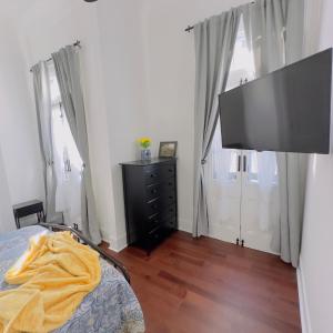 a bedroom with a bed and a flat screen tv at Walk to French Quarter House of Jazz & Blue Suite in New Orleans