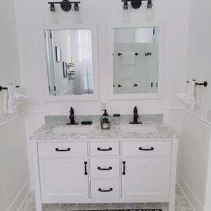a white bathroom with two sinks and two mirrors at Walk to French Quarter House of Jazz & Blue Suite in New Orleans