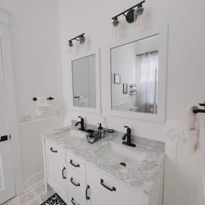 a white bathroom with a sink and two mirrors at Walk to French Quarter House of Jazz & Blue Suite in New Orleans