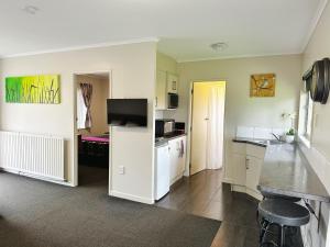 a kitchen with white cabinets and a counter top at Red Rock Thermal Motel - Mineral Pool in Rotorua