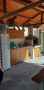 コスティネシュティにあるCasa Trofinのキッチン(木製キャビネット、白い冷蔵庫付)