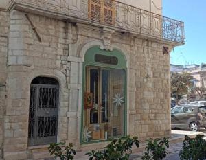 a stone building with a balcony and a door at Ognissanti80 in Trani