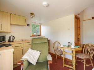 een kleine keuken met een tafel en stoelen en een tafel bij Wren's Nest in Keswick