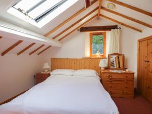 een slaapkamer met een wit bed en een raam bij Wren's Nest in Keswick