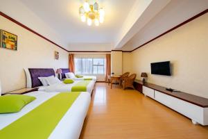 Habitación de hotel con 2 camas y TV en Ha Luo Hotel, en Kunming