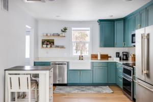 una cocina con armarios de color turquesa y encimeras blancas en Medicine Lake Manor, en Minneapolis