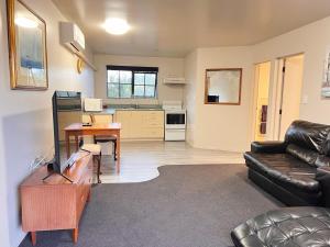 - un salon avec un canapé et une table dans l'établissement Kingswood Manor Motel, à Whangarei