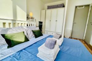 1 cama grande con sábanas azules y almohadas verdes en High-Class 2BED Condo Just 1-Step from BTS ONNUT en Bangkok