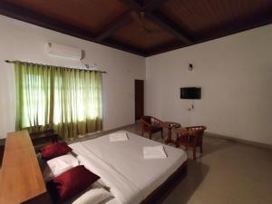 a bedroom with a bed and a table and chairs at AZZA Heritage Home in Cochin
