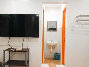 a bathroom with a tv on the wall and a sink at Island Inn in Boracay