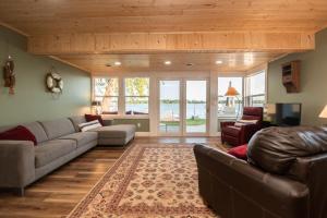 a living room with a couch and a tv at Water's Edge Retreat 