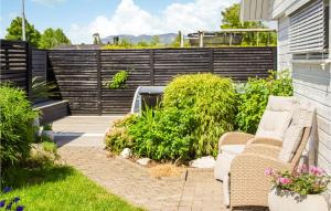 a backyard with white chairs and a fence at Pet Friendly Home In Skien With Private Swimming Pool, Can Be Inside Or Outside in Skien