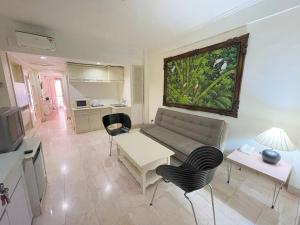 a living room with a couch and a table and chairs at Beach Apartment inside Resort Walking Distance to the beach in Seminyak
