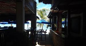 un ristorante con sedie e ombrelloni sulla spiaggia di birdwatchers beachfront hotel panglao a Panglao