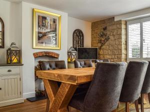 a dining room with a wooden table and chairs at Chapel House in Bourton on the Water