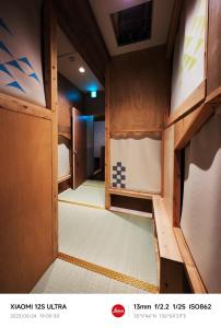 an empty room with wooden walls and a door at 2023年6月開業 サカエ ゲストハウス in Nagoya