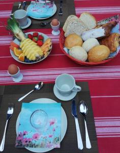 una mesa cubierta con platos de comida y tazones de pan en B&B Lora, en Langemark