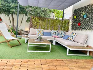 un patio con sofá y mesa en Villa Paradise, urban oasis by -Toprentalsbarcelona-, en Esplugues de Llobregat