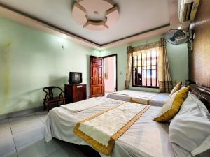 a bedroom with a large bed and a ceiling fan at Nhật Anh Hotel Cát Bà in Cat Ba