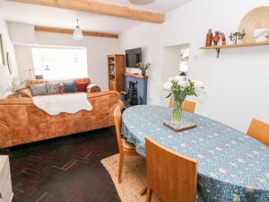 ein Wohnzimmer mit einem Tisch und einem Sofa in der Unterkunft 3 Bridge Villas in Narberth