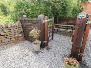 a garden with a wooden gate and a bench at 3 Bridge Villas in Narberth