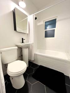 a bathroom with a toilet and a sink and a tub at Heart of Hollywood Apartment - 2Bed 2Bath in Los Angeles +14 photos