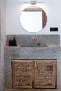 a bathroom with a mirror and a wooden cabinet at The Well in Ahangama