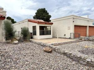 a house with a gravel driveway in front of it at Townhouse, two car garage, fireplace back yard in Las Cruces