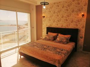 a bedroom with a bed and a large window at La perle bleue in La Goulette