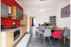eine Küche mit einem Holztisch und blauen Stühlen in der Unterkunft NEW ShalalaLiving Vienna Spacious Home for Family & Friends in Wien