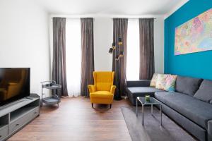 ein Wohnzimmer mit einem Sofa und einem TV in der Unterkunft NEW ShalalaLiving Vienna Spacious Home for Family & Friends in Wien