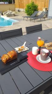 - une table avec une assiette de nourriture et une tasse de jus d'orange dans l'établissement Location en nuitée, à Abeilhan