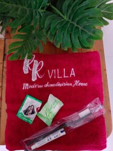 une serviette rouge avec un thermomètre et un stylo dessus dans l'établissement Villa RR, à Bandungan