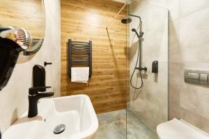 a bathroom with a sink and a shower at Apartamenty Na Skarpie in Płock