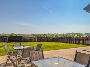 a patio with tables and chairs and a view of a yard at Fell View Cottage - Uk43378 in Kirklinton