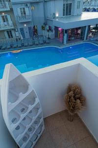 une piscine avec un vase installé à côté d'un mur blanc dans l'établissement LA SAN PEDRO I Laganas Karydakis, à Laganas