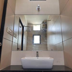 a bathroom with a sink and a mirror at Hotel Unnati in Aurangabad