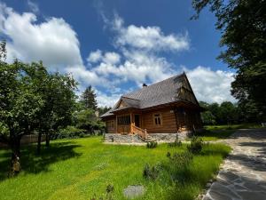 a log cabin in a field of green grass at Organistówka in Rabka-Zdrój