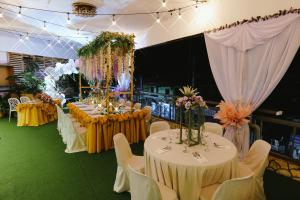 um salão de banquetes com mesas, cadeiras e flores em Boracay Grace Hotel em Boracay